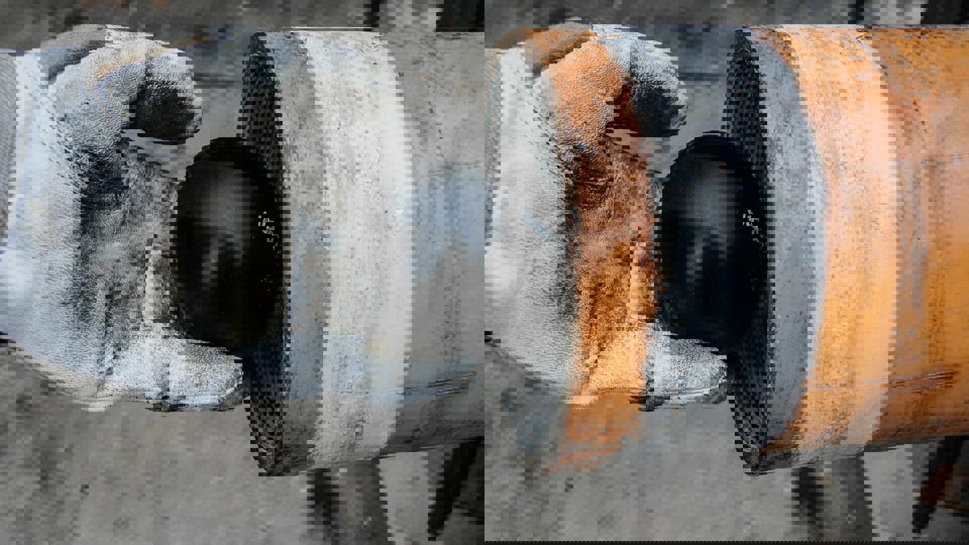 A hand is placing a black ball into a piece of downhole hardware, demonstrating Welltec downhole solutions.