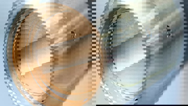 Closeup view of a polished metallic tool with a hollow cylindrical opening for downhole operations.