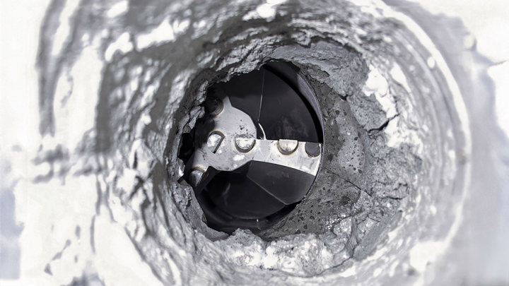 Downhole tool removing thick carbonate scale buildup inside wellbore to restore access and maintain production flow.