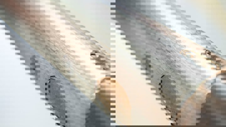 Close up of a polished metal tool surface showing gas lift valve components used in downhole oil and gas operations