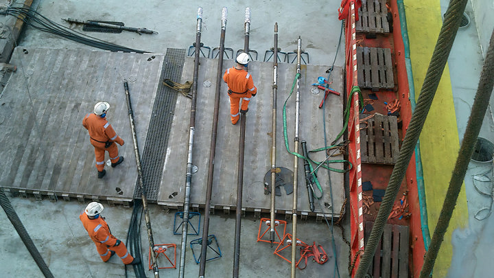 Engineers prepare downhole tools on rig deck for well intervention focused on efficient downhole water management.