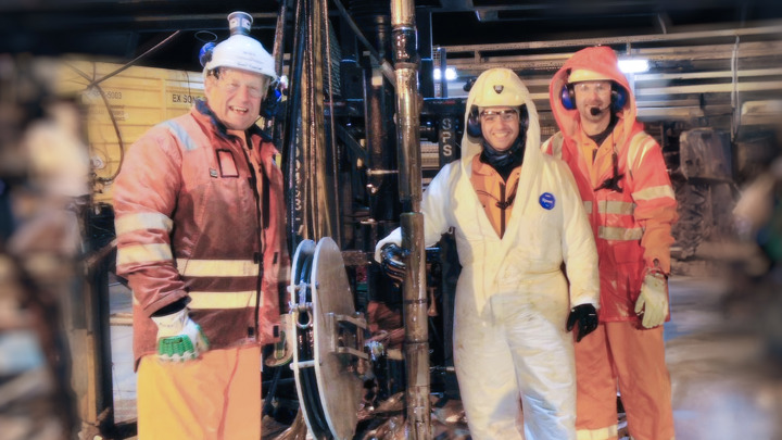 Three engineers in safety gear posing together on a drilling platform, celebrating a successful operation to retrieve multiple fish using the HIROS tool.