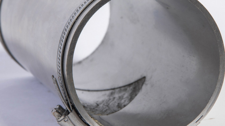 Close-up of an Isealate Springblade Patch showing its expanded laminate steel structure, used to seal a parted connection and resume frac operations