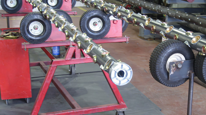 Tool setup for 11-stage through-patch tractoring operation, achieving zero NPT during well intervention, shown mounted on red support stands.