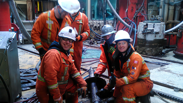 Offshore engineers in orange safety gear and helmets safely clean and pull a bridge plug during Welltec® operations offshore Canada.