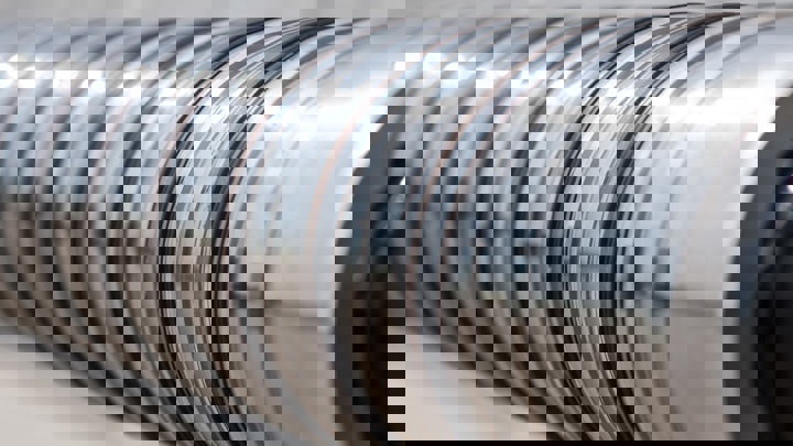 Close up view of a polished metal expandable tool component used in wellbore completion to create a reliable and durable seal in the well