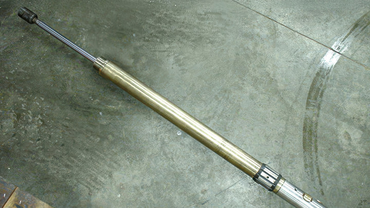 E-line tool assembly laid out on concrete floor, used to retrieve a stuck monolock plug during well intervention.