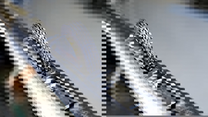 Close up of a Well Tractor wheel showing its detailed tread pattern on a metallic cylindrical surface.